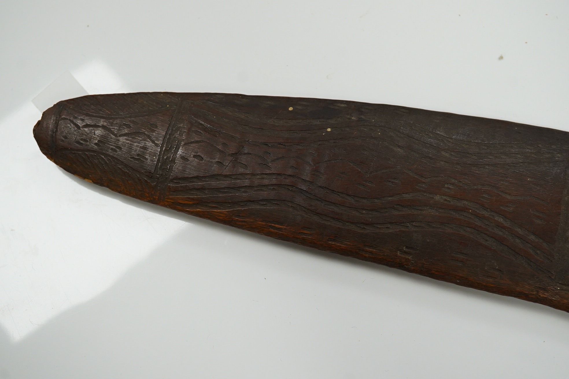 An Aboriginal boomerang, engraved to one side, 76cm wide. Condition - fair to good